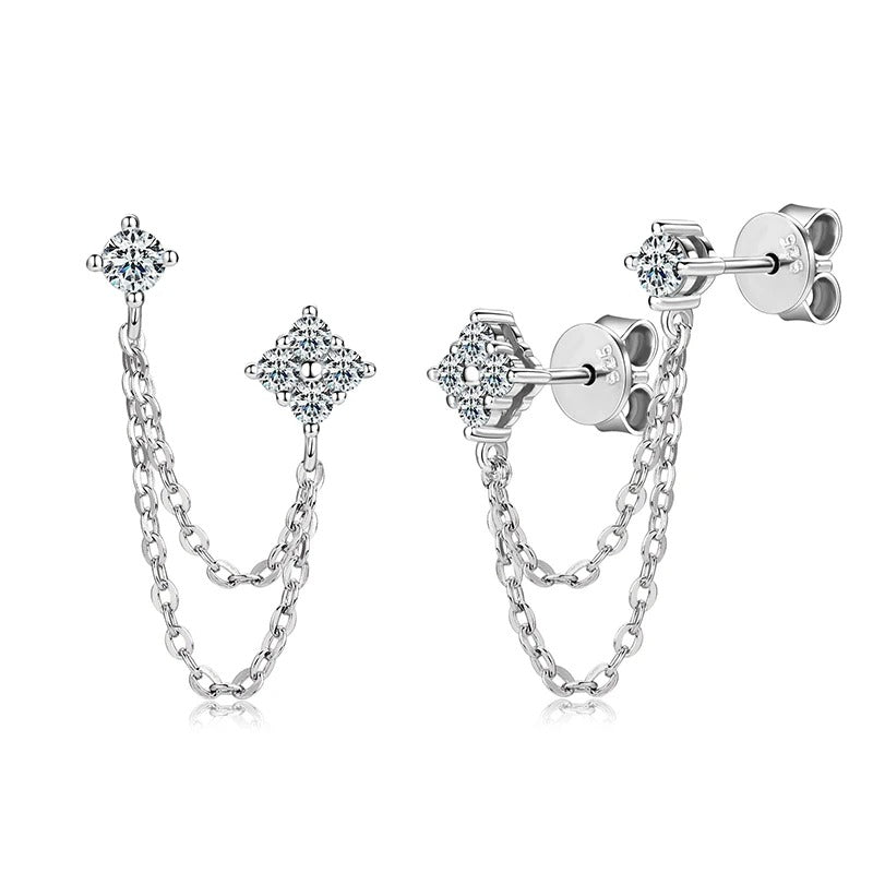 Close-up of moissanite stud earrings with fine tassel chain drops, shown in a silver finish with a bright reflective sparkle.